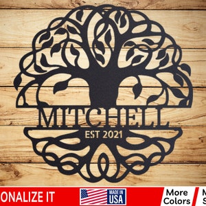 May include: Black metal tree of life wall art with the name "MITCHELL" and the date "EST 2021" inscribed below the tree.