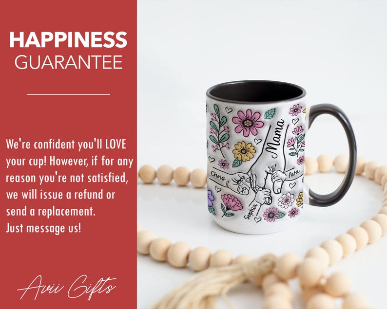 Op de afbeelding: Witte keramische mok met een zwart handvat en rand, versierd met kleurrijke bloemen en het woord "Mama". De mok heeft een hand-vasthoudend ontwerp met de namen "Chris", "Sophia" en "Ava". De tekst "Happiness Guarantee" is ook zichtbaar.