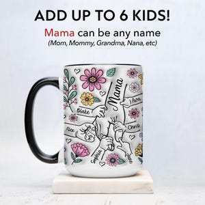 Op de afbeelding: Witte keramische mok met een zwart handvat, versierd met bloemen en het woord "Mama". De mok heeft de tekst "Add up to 6 kids!" en namen als "Blake", "Alex", "Sophia", "Chris", "Ava" en "Jane".