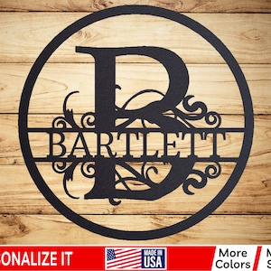 May include: A black metal circle with a decorative scroll design and the letter "B" in the center. The name "BARTLETT" is written across the center of the circle.