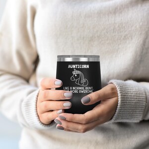 May include: Black stainless steel wine tumbler with a white unicorn graphic and the text "Aunticorn Like a normal aunt, but more awesome".
