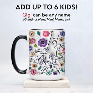 Puede incluir: Taza de caf&eacute; de cer&aacute;mica blanca con asa negra. La taza tiene un dise&ntilde;o colorido de flores e huellas de manos con nombres escritos en cada mano. El texto "ADD UP TO 6 KIDS!" est&aacute; en la parte superior de la taza. El texto "Gigi can be any name (Grandma, Nana, Mimi, Mama, etc)" est&aacute; debajo del dise&ntilde;o. Los nombres en las manos son Alex, Blake, Sophia, Jane, Ava y Chris.