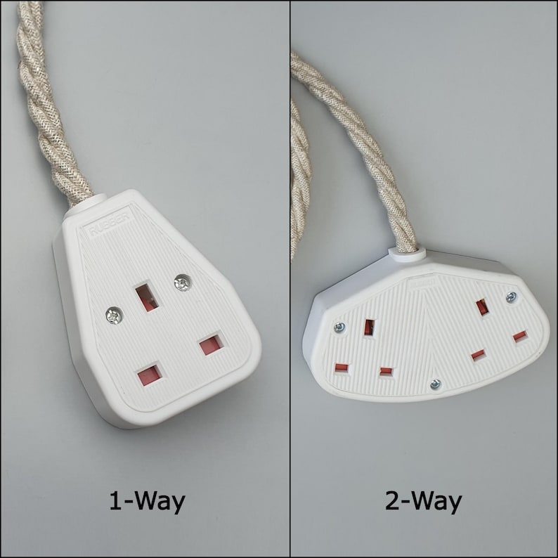 Op de afbeelding: Witte stopcontacten met beige gevlochten snoeren. De afbeelding toont een 1-weg en een 2-weg stopcontact. De stopcontacten hebben rode en zwarte openingen voor stekkers. De tekst "1-Way" en "2-Way" staat eronder.