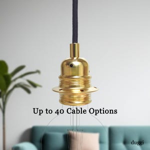 May include: A brass-coloured light fitting with a black cord. The fitting has a bulb socket and a decorative base. Text on the image reads "Up to 40 Cable Options".