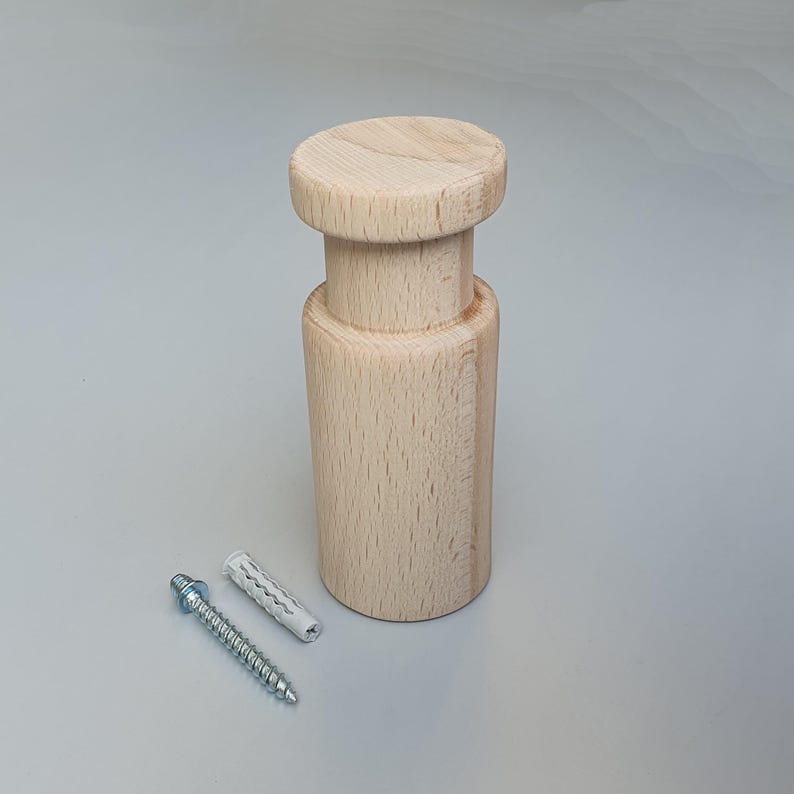May include: A natural wood wall mount with a round top and a cylindrical base. It comes with a screw and a plastic anchor for installation.
