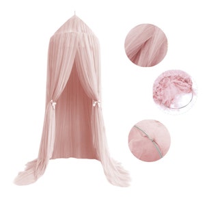 Pode incluir: Um dossel de tule rosa com um la&ccedil;o branco de cada lado. O dossel &eacute; feito de um tecido macio e transparente, perfeito para criar um espa&ccedil;o aconchegante e fant&aacute;stico.
