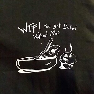 Könnte beinhalten: Ein schwarzes T-Shirt mit weißem Text, der "WTF! You got baked without me?" lautet, und einer Cartoon-Illustration einer Person in einer Schüssel und einem Cupcake.