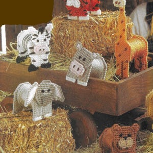 Pode incluir: Um conjunto de seis figuras de animais de tela plástica, incluindo uma zebra, um tigre, uma girafa, um elefante, um hipopótamo e um urso. As figuras estão dispostas em fardos de feno e em uma carroça de madeira.
