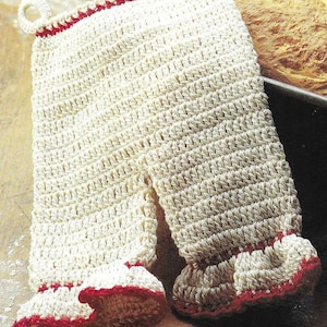 May include: White crocheted oven mitt with red trim. The mitt is shaped like a pair of pants with a loop at the top.