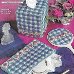 Puede incluir: Tapa de caja de pañuelos, espejo de mano y bandeja de tocador de tejido gingham azul y blanco con un diseño floral.  "Blue Gingham BATH TRIO" y "By Sandra Miller Maxfield" están impresos en la imagen.