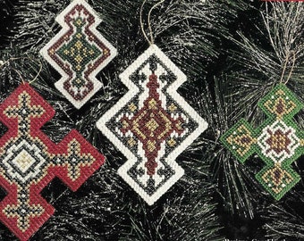 May include: Four handmade Christmas ornaments with geometric patterns. The ornaments are made with beads in red, green, white, black, and gold.
