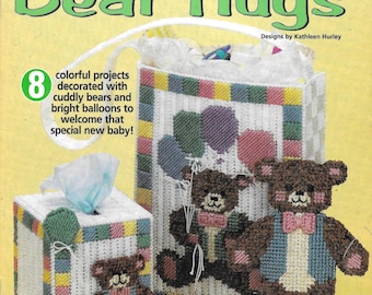 Pode incluir: Um padrão de artesanato de tela plástica com oito projetos coloridos decorados com ursos de pelúcia e balões brilhantes. O título do padrão é "Baby Bear Hugs".