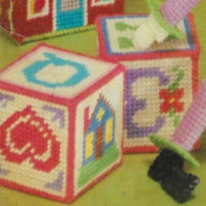 Puede incluir: Un conjunto de bloques de tela bordados de colores vivos con diferentes diseños, incluyendo una casa, una flor y la letra O. Los bloques están hechos de una tela suave y texturizada y son perfectos para la sala de juegos de un niño.