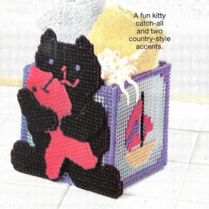 May include: A black cat-shaped catch-all container with a red fish. The container is a cube with a sailboat design. The text reads: "A fun kitty catch-all and two country-style accents."