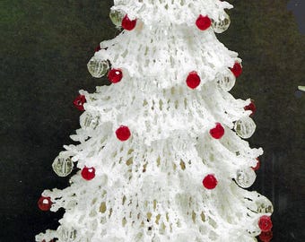 Puede incluir: Un árbol de Navidad blanco tejido a mano con adornos de cuentas rojas y transparentes. El árbol está rematado con una estrella blanca y es una decoración festiva. El árbol mide aproximadamente 25 cm de altura.