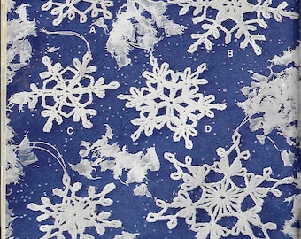 May include: Six white crocheted snowflakes on a blue background. The snowflakes are all different designs and are hanging from strings. The snowflakes are labeled with letters A through F.