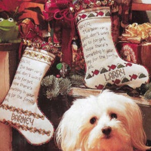 May include: Two white Christmas stockings with red and green trim and personalized messages for "Barney" and "Larry". The stockings are hanging on a wooden surface with a small dog in the foreground.