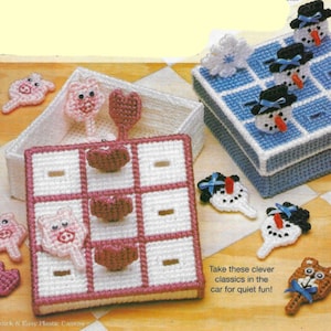 May include: Two plastic canvas game sets, one with a pink and white tic-tac-toe board and pink pig pieces, the other with a blue and white tic-tac-toe board and white snowman pieces.  The text "Take these clever classics in the car for quiet fun!" is printed below the game sets.