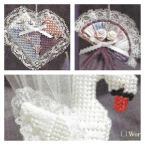 May include: Three handmade ornaments: a heart-shaped ornament with a lace border, a fan-shaped ornament with a lace border and a bow, and a white swan ornament with a red beak.