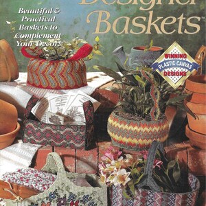 Può includere: Una collezione di quattro cesti in tela plastica con diversi design. I cesti sono decorati con motivi geometrici colorati e motivi floreali. I cesti sono esposti su una superficie di mattoni con una pianta in vaso e un annaffiatoio. Il testo "Designer Baskets" è visualizzato nella parte superiore dell'immagine. Il testo "Winning Plastic Canvas Designs" è visualizzato in un cerchio rosso e bianco nella parte inferiore dell'immagine.