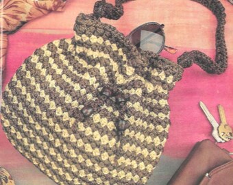 May include: A brown and beige crocheted bag with a drawstring closure and a long strap. The bag is decorated with brown wooden beads.