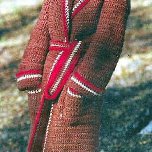 May include: A brown crocheted coat with a white and red trim. The coat has a shawl collar, a belt, and pockets. The model is wearing a matching hat.