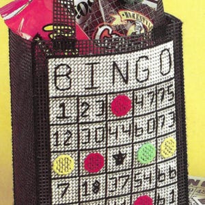 May include: A black canvas tote bag with a white "BINGO" design. The bag has a grid with numbers and colored circles. The bag is filled with snacks.