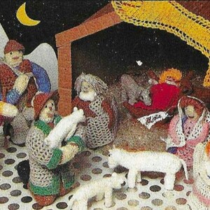 May include: A crocheted nativity scene with a star, a manger, and figures of Mary, Joseph, baby Jesus, and angels. The figures are all dressed in white, blue, and red.