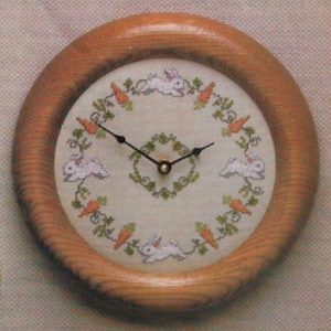 Könnte beinhalten: Eine Uhr mit Holzrahmen, weißem Hintergrund und einem Design aus Hasen und Karotten um das Zifferblatt.