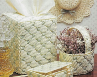 May include: A collection of handmade, off-white plastic canvas items. Includes a tissue box, a small basket filled with dried flowers, a jewelry box, and a decorative hat. The items have a diamond pattern with light green accents.