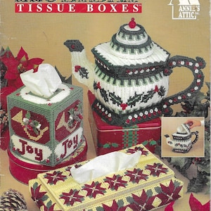 Puede incluir: Fundas de cajas de pañuelos de plástico con temática navideña. La imagen presenta una funda en forma de tetera, una funda rectangular y una funda cuadrada, todas con diseños festivos en rojo, verde y blanco. El texto "HOLIDAY TISSUE BOXES" está en la parte superior.