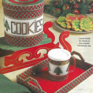 May include: A Christmas-themed craft set featuring a red and green cookie jar with the word "COOKIES" on the front, a red and green mug, and a red and green tray. The set is decorated with a Christmas tree design.