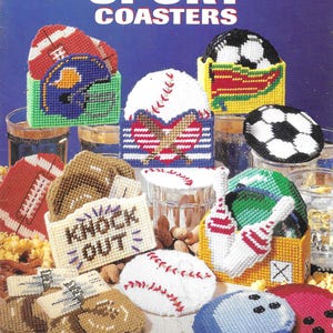 Puede incluir: Un conjunto de posavasos de lona de plástico con varios temas deportivos. Los diseños incluyen balones de fútbol americano, béisbol, fútbol y bolos. Los posavasos son de varios colores, como rojo, blanco, azul y verde. El texto "SPORT COASTERS" es visible.