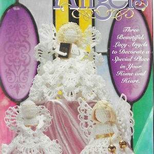 Puede incluir: Tres ángeles de ganchillo, cada uno con un diseño diferente, se muestran sobre una superficie rosa. Los ángeles son blancos y tienen delicados detalles de encaje. El texto "Petite Angels" se muestra en la parte superior de la imagen.