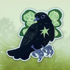 Peut inclure: Un autocollant représentant un oiseau noir stylisé avec une étoile sur la poitrine et des ailes vertes en forme de feuilles. L'oiseau a des pieds violets et un bec violet. Le fond est vert clair avec une ligne d'arbres floue.