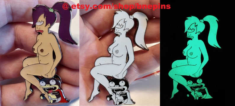 May include: A set of three enamel pins featuring a cartoon character. The first pin is in color, the second is in black and white, and the third glows in the dark. All three pins feature the same image of a woman sitting on a creature with a large mouth.