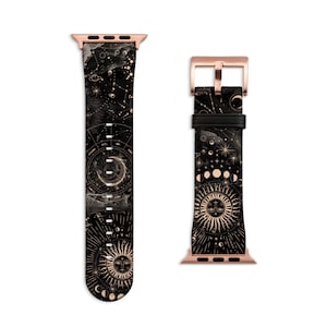 Peut inclure: Un bracelet de montre Apple en cuir noir avec une boucle dor&eacute;e et un imprim&eacute; c&eacute;leste repr&eacute;sentant des constellations, des lunes et un soleil avec un visage.