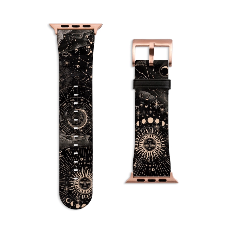 Peut inclure: Un bracelet de montre Apple en cuir noir avec une boucle dor&eacute;e et un imprim&eacute; c&eacute;leste repr&eacute;sentant des constellations, des lunes et un soleil avec un visage.