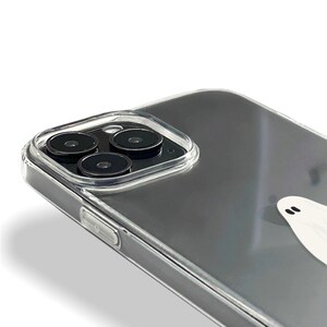 May include: A clear phone case with a ghost design. The case has a raised camera bump with three black camera lenses.