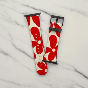 May include: A red and white floral patterned Apple Watch band with a black buckle.