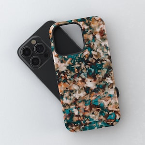 Puede incluir: Un teléfono inteligente negro con una funda protectora de patrón abstracto multicolor. El diseño consiste en parches mezclados de color verde azulado, marrón oscuro, blanco y bronceado, creando una apariencia texturizada similar a la piedra.