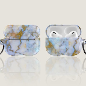May include: A white and gold marble patterned case for AirPods with a silver keychain attached. The case is open and the AirPods are visible inside.