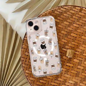 May include: Clear iPhone case adorned with a coffee-themed design. The case displays illustrations of coffee cups, iced coffees, and takeaway cups in brown and beige tones. The phone case is on a woven surface.