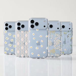 May include: Five clear smartphone cases arranged in a row, each featuring distinct floral patterns including white daisies, soft pink geometric flowers, and delicate wildflower prints. The cases are displayed against a light background with the text theurbanflair.com.