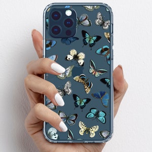 Op de afbeelding: Een transparante telefoonhoes met een blauwe achtergrond en een patroon van kleurrijke vlinders. De hoes is ontworpen voor een iPhone met een vierkante camera lens.