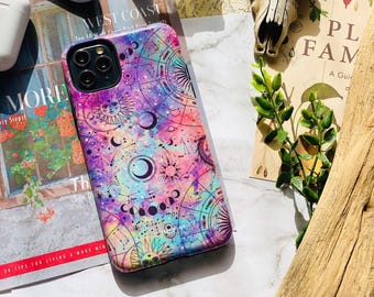 May include: A smartphone case featuring a vibrant, multi-colored nebula background with purple, pink, and blue hues. The design includes intricate black line art of celestial bodies, including suns, moons, star charts, and zodiac symbols.