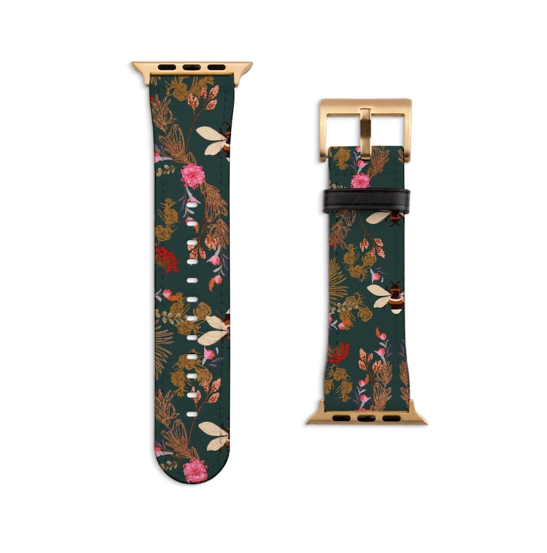 May include: A green leather Apple Watch band with a floral and bee pattern. The band has a gold buckle and a gold adapter.