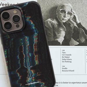 May include: A black smartphone case featuring a distorted, glitch-style pattern with iridescent rainbow light streaks. The case has a cutout for a triple-lens camera system and the text THEURBANFLAIR printed in white near the bottom edge.