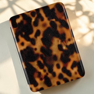 May include: A rectangular protective case for an electronic reader featuring a glossy tortoiseshell pattern in shades of brown, amber, and black. The side of the case displays the text THEURBANFLAIR.COM and THEURBANFLAIR.ETSY.COM in small white letters.