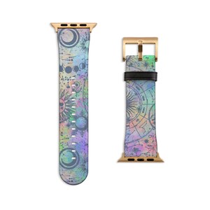 K&ouml;nnte beinhalten: Ein zweiteiliges Uhrenarmband mit einem Himmelsdruck aus Monden, Sonnen und Sternbildern in Lila-, Blau- und Gr&uuml;nt&ouml;nen. Das Armband verf&uuml;gt &uuml;ber goldfarbene Metallanschl&uuml;sse und eine goldfarbene Schlie&szlig;e mit einer schwarzen Schlaufe aus Leder.